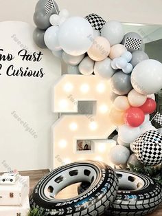 the balloon arch is decorated with black and white balloons, checkered tires, and a number