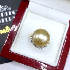 A lustrous pearl, cocktail ring is a need for every lady in the world. What could get you more attention than having this huge, exotic, and sparkling pearl ring on your finger while holding a glass of wine? We are presenting you with a Huge GOLDEN SOUTH SEA PEARL, absolutely natural color and TOP AA+ luster, 14 mm in size, surrounded by 22 pieces of hand-set F/VS superb quality diamonds, weighting at 0.64 carat. Set in handcrafted, one of a kind 18K solid white gold ring, weighting at 8.0 grams. Luxury Pearl Diamond Ring As Gift, Elegant Pearl Ring For Party, Elegant Pear-shaped Diamond Ring Gift, Elegant Silver Pearl Ring For Party, Diamond Pearl Ring With High Luster For Gift, Gift Pearl Ring With High Luster And Diamond, Golden South Sea Pearls, Sea Pearl, Sea Pearls