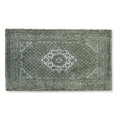 a green rug with an intricate design on the front and back side, in white