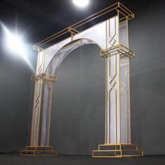 an arch in the middle of a room with light shining on it's sides