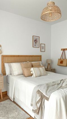 a bedroom with a bed, nightstands and pictures hanging on the wall above it