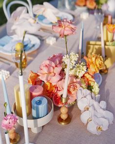 a table topped with lots of flowers and candles