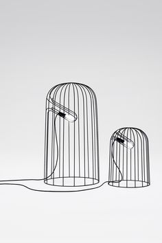 two birdcages sitting next to each other in front of a blue dot on the ground