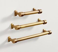 three brass - plated handles are hanging on the wall, and there is no image to describe