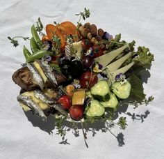 a pile of food sitting on top of a white table covered in veggies