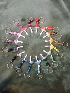 several pairs of scissors are arranged in a circle on a green surface, with small rings around them