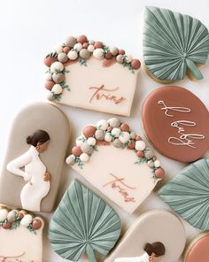 decorated cookies are arranged in the shape of hearts and palm leaves with names on them