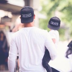 two people walking down the street with hats on their heads and one person wearing a white shirt