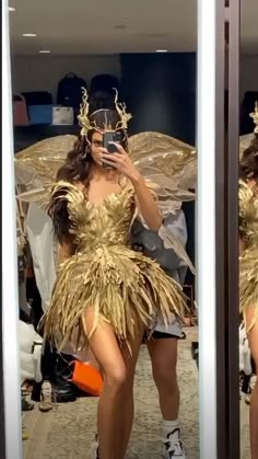 a woman is taking a selfie in a mirror wearing a gold dress and headpiece