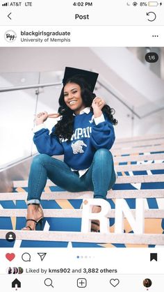 a woman in a graduation cap and blue jeans sitting on the stairs with her arms up