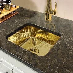 a kitchen counter with a gold sink in it