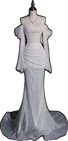 a white dress with long sleeves on top of a mannequin headdress