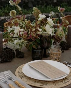 the table is set with silverware and flowers