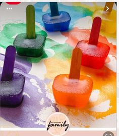 popsicles that are sitting on top of each other in front of some watercolors