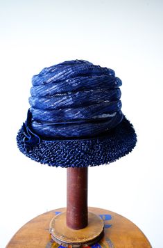 "DESCRIPTION * vintage hat from 1950s-1960s. * cloche style: close-fitting high crown, worn low on the forehead, short brim * the brim is upturned in the back * navy blue woven straw * decorated with translucent tube straw, coiling to the top of hat * hatband is wrapped with thick velvet ribbon and decorated with a bow on the side * no tag CONDITION * hat is in good condition. A small area of the tube decoration is slightly crushed as shown in the last photo. Need simple cleaning and reshaping. Fitted Flapper Cloche Hat With Brim, Vintage Cloche Hat With Short Brim For Parties, Vintage Wide Brim Fitted Cloche Hat, Vintage Fitted Wide Brim Cloche Hat, Retro Fitted Cloche Hat, Fitted Wide Brim Vintage Cloche Hat, Fitted Flapper Cloche Hat With Curved Brim, Vintage Cloche Hat For Spring Evenings, Vintage Brimmed Cloche Hat For Party