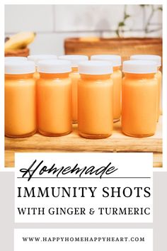 six jars filled with orange liquid on top of a wooden table