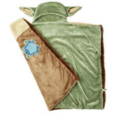 a green and brown blanket with a blue turtle on the front, sitting next to it's back