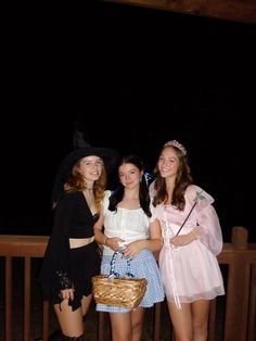 three girls dressed up in costumes posing for the camera