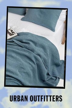 an image of a bed with blue sheets and pillows on it that reads urban outfitters