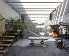 an indoor area with stairs, tables and bikes