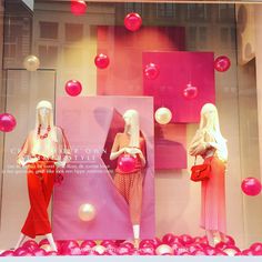 two mannequins dressed in red and pink with balloons