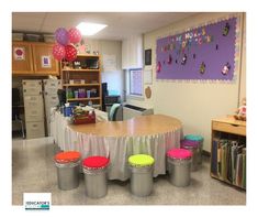 an empty classroom with round tables and colorful stools