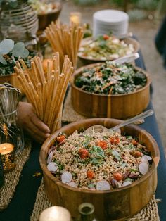 a table topped with wooden bowls filled with food