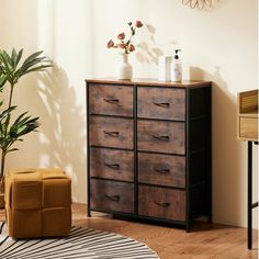 a wooden dresser sitting on top of a hard wood floor next to a potted plant