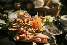 an assortment of appetizers on a table with candles and other foods in the background