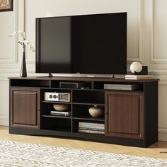 a flat screen tv sitting on top of a wooden entertainment center in a living room