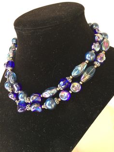 Vintage TRIFARI double strand beaded necklace in excellent condition.  The necklace consists of varying beads in shades of blue, aurora borealis, filigree caps, and silvertone spacer beads.  It is signed TRIFARI on the hook. This is a stunning necklace and designed with the quality and craftsmanship that vintage TRIFARI costume jewelry was known for.  Though a vintage piece, it is perfect for even todays fashion. READ...the 3rd bead from the clasp has a slight imperfection which can be seen in a photo, however this does not take away from the beauty of this necklace.  A potential heirloom piece! Thanks for shopping alliesjewelbox.Etsy.com Jan Traditional Blue Multi-strand Beaded Necklaces, Vintage Blue Double Strand Necklaces, Blue Multi-strand Beaded Necklace, Vintage Multi-strand Beaded Necklace With Polished Beads, Blue Multi-strand Necklace With Polished Beads, Choker Collar Necklace, Vintage Trifari, Choker Collar, Stunning Necklace