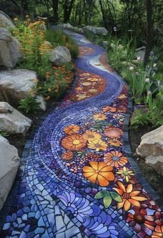 a colorful walkway with flowers painted on the side and rocks in the backround