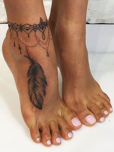 a woman's foot with a feather and beads tattoo on the bottom of it