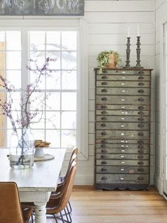 a dining room table and chairs in front of a large window with white shiping