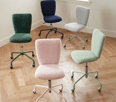 four office chairs in various colors and sizes on a wooden floor next to a window