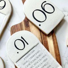 some cookies with numbers on them sitting on a cutting board next to spoons and utensils