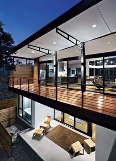 a modern house with wooden decking and glass walls