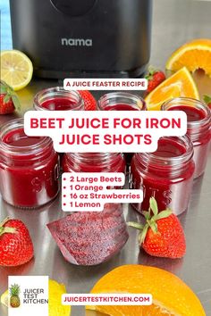 a bunch of jars filled with juice sitting on top of a counter next to sliced oranges and strawberries