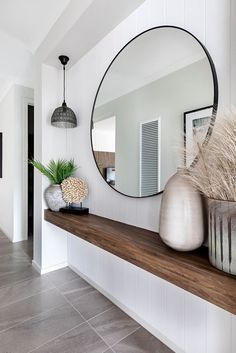 there is a mirror and vases on the shelf in this room with tile flooring