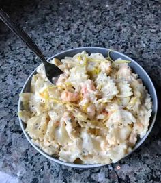 a bowl filled with pasta and shrimp on top of a table