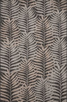 a black and white rug with large leaves on the side, in front of a gray background