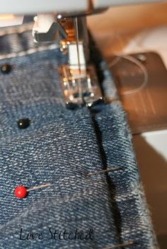 the sewing machine is working on the jeans that have been sewn together and are stitched together