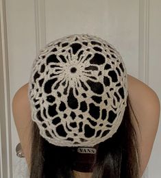 a woman with long hair wearing a white and black crochet hat