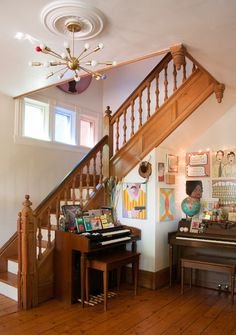 the stairs are decorated with pictures and posters on them, along with a piano in the foreground