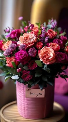 a bouquet of flowers sitting on top of a wooden table next to a sign that says for you