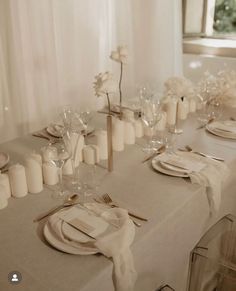 the table is set with white plates and silverware