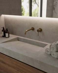 a bathroom sink with two soap dispensers next to it and towels on the counter