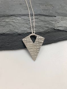 This unique modern silver triangle necklace has been entirely handmade using .999 fine silver. It has been cut from fine silver precious metal clay, textured, fired and oxidized. The pendant hangs from a sterling silver diamond cut cable chain. This unique modern pendant necklace features a basket weave pattern. Pendant size: approximately 1 x 3/4 inches Chain length: adjustable at 16 and 18 inches can also be customized to whatever length needed The necklace is sent in a gift box. This jewelry Unique Triangle Sterling Silver Jewelry, Handmade Triangle Sterling Silver Jewelry, Handmade Sterling Silver Triangle Jewelry, Modern Sterling Silver Etched Jewelry, Modern Etched Sterling Silver Jewelry, Unique Silver Geometric Jewelry, Silver Triangle Jewelry Gift, Silver Triangle Jewelry For Gifts, Silver Triangle Jewelry For Gift