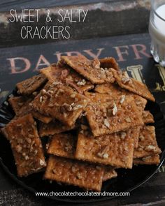 sweet and salty crackers on a black plate next to a glass of milk