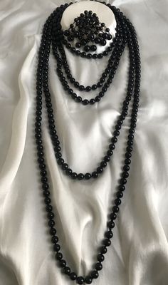 Vintage extremely stylish black Czech glass jewelry. Set of two long necklaces and a brooch, made in the 50s. Multi-strand beaded necklaces were immensely popular in 1950s. Heavy glass necklaces made of Czech shiny black beads in decadent Sautoir or Rope style. Made in the best tradition, each bead is knotted. Many uses for this jewelry. The length of the beads with lock is 65cm (130cm). Length of beads without lock 91cm (183cm). Diameter of glass beads 7-8 mm. Brooch size 27/60mm, heavy and tin Formal Black Multi-strand Beaded Necklaces, Formal Multi-strand Black Beaded Necklaces, Formal Multi-strand Black Beaded Necklace, Formal Black Multi-strand Beaded Necklace, Classic Necklaces With Round Beads For Evening, Black Beaded Necklace For Formal Costume Jewelry, Formal Black Beaded Costume Jewelry Necklace, Black Beaded Costume Jewelry Necklace For Formal Occasions, Formal Black Beaded Costume Necklace